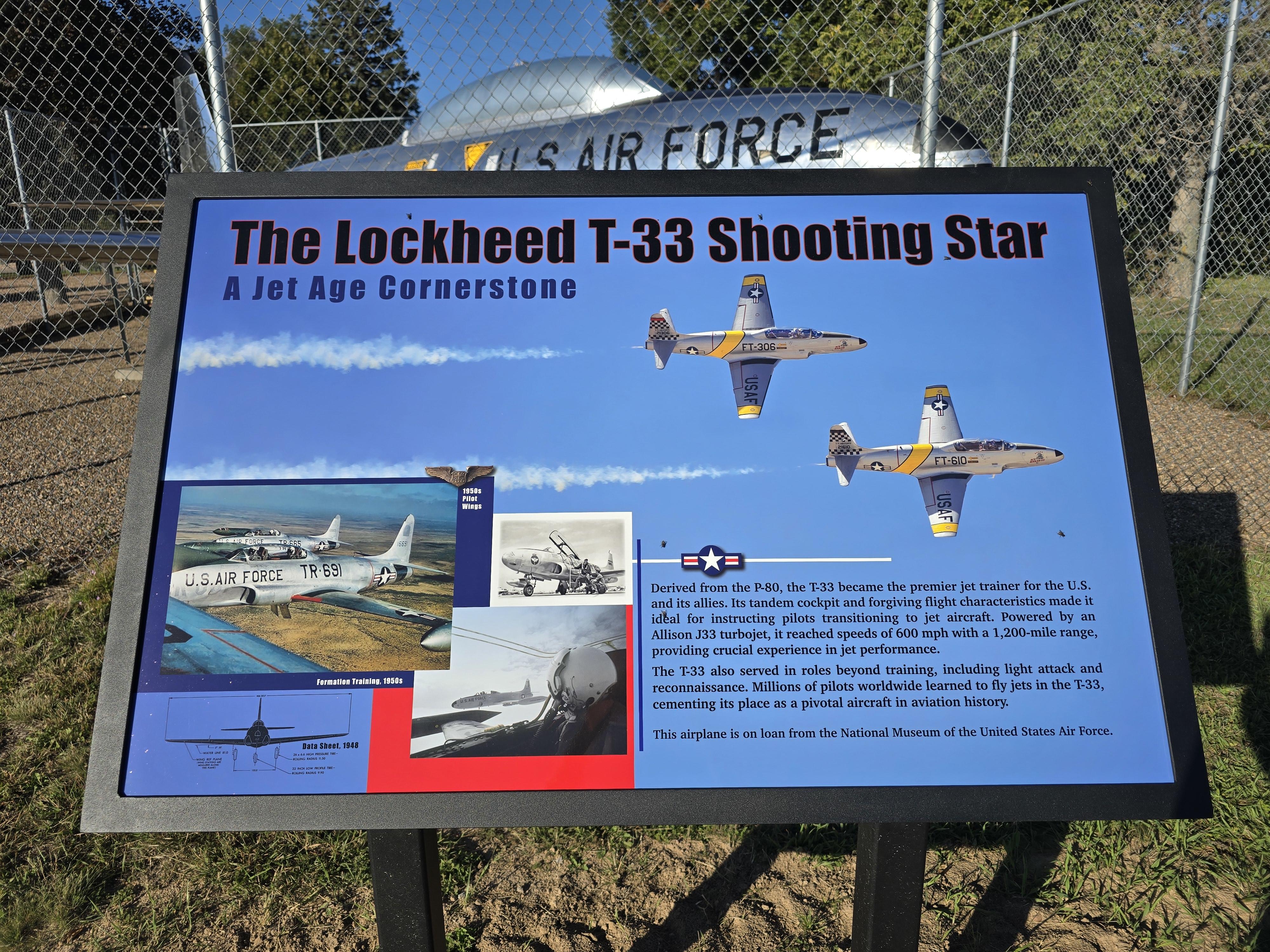 Blue sign with 4 flying silver jets, black print 